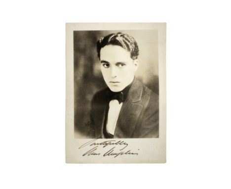 Charles Chaplin: An early signed publicity photograph,circa 1917,a vintage sepia photograph printed on card stock featuring a