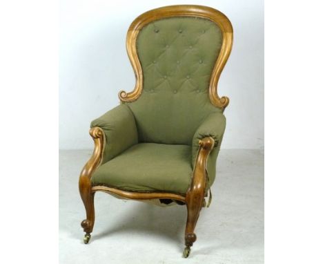 A Victorian walnut nursing chair, with green button back fabric, raised on shaped legs and brass castors, 66 by 73 by 102cm h