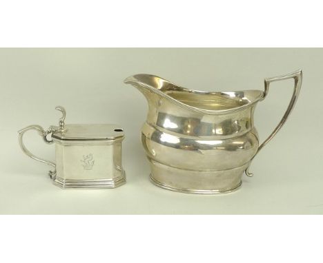 A silver mustard pot with clear glass liner, of rectangular canted form, crest engraved, with a raised thumb piece and hinged