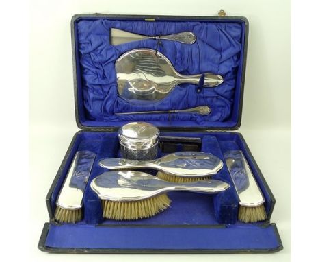 A silver dressing table / travelling set, monogram engraved, comprising four brushes, hair tidy, comb, shoe horn, button hook