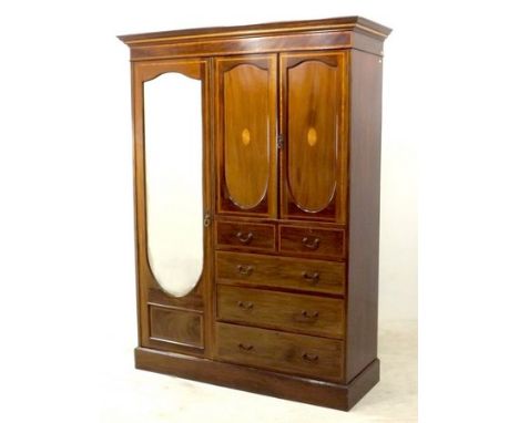 An Edwardian mahogany, line inlaid and crossbanded compactum, outswept cornice over a single bevelled mirrored door revealing