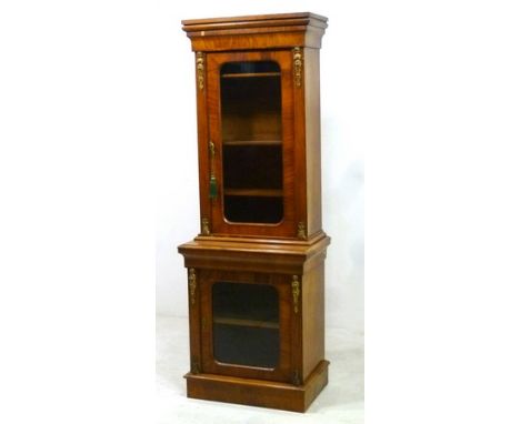 A Victorian walnut veneered, cross banded and line inlaid display cabinet, with gilded brass fittings, the outswept cornice o