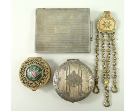 A white metal compact with engine turned decoration, a circular compact engraved with a basket of flowers within a foliate sc