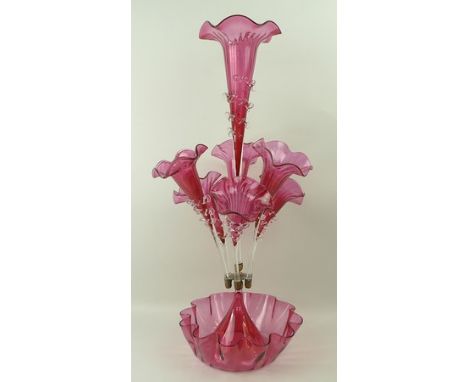 A Victorian cranberry glass epergne with a central trumpet surrounded by six smaller, each with spiral frill decoration, the 