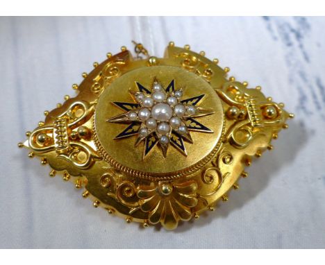 A Victorian filigree mourning brooch with seed pearl and blue enamel star motif, glazed locket to the rear, 13.4 gm gross (un