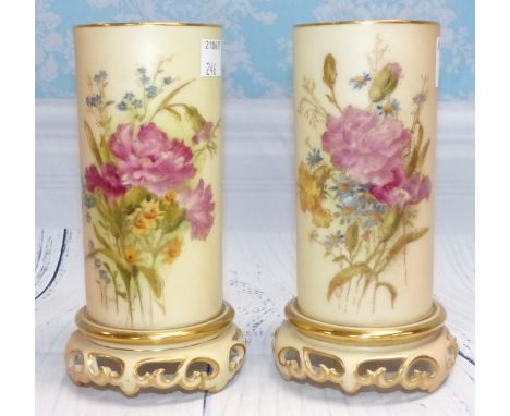 A pair of late 19th Century Royal Worcester porcelain cylindrical vases hand painted with floral decoration against a peach b