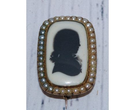 An early 19th century silhouette miniature portrait on ivory, in yellow metal brooch mount (untested), with seed pearl border