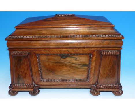 A late Georgian rosewood sarcophagus shaped tea caddy with reeded decoration, on bun feet, original fitted interior with glas