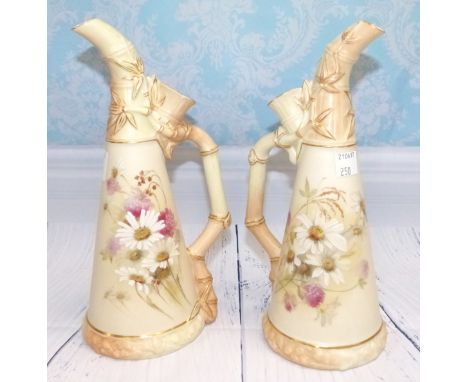 A pair of late 19th Century Royal Worcester porcelain jugs with of tapering conical form, in ivory, with elongated curved spo