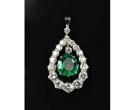 An emerald and diamond pendant, claw set with the shaped step cut emerald at the centre and with a circular cut diamond mount