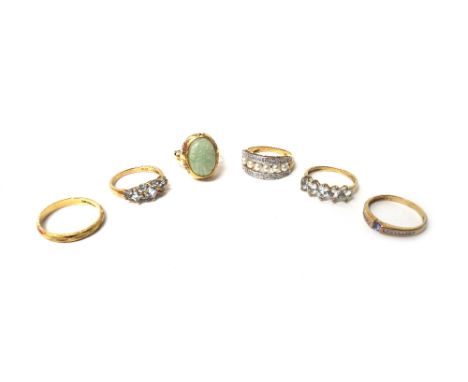 A 14ct gold ring, mounted with a carved oval jade, an 18ct gold wedding ring, a 9ct gold ring, mounted with a row of cultured