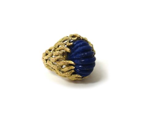 A gold ring, claw set with an oval ridged lapis lazuli, the mount in a cast and pierced marine foliate design, ring size M, g