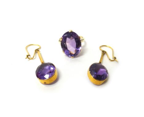 A gold ring, claw set with an oval cut amethyst, ring size K and a pair of amethyst set single stone pendant earrings, each m