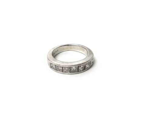 A platinum and diamond set half hoop ring, mounted with a row of seven princess cut diamonds, ring size K, gross weight 9 gms