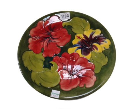 Four Moorcroft green ground plates, circa 1930, two hibiscus and two anemone, with impressed and painted marks, 26cm diameter