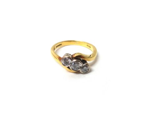 An 18ct gold and diamond set three stone ring, collet set with a row of circular cut diamonds, in a crossover design, ring si