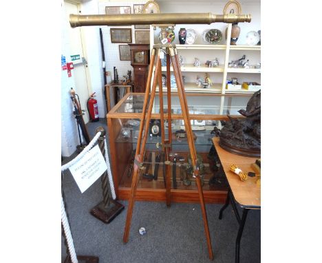 A reproduction brass cased telescope on a wooden adjustable tripod stand, the telescope 97cm.