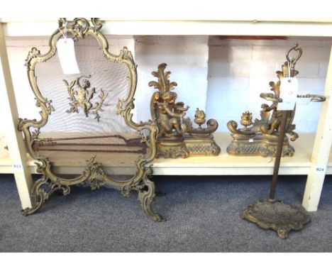 A pair of Victorian gilt bronze fire chenets, each modelled and cast with a Cupid figure warming his hand over a flaming urn,
