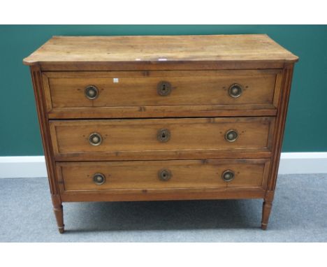 A late 18th century Italian fruitwood commode, with three long drawers flanked by fluted rounded corners, on turned supports,