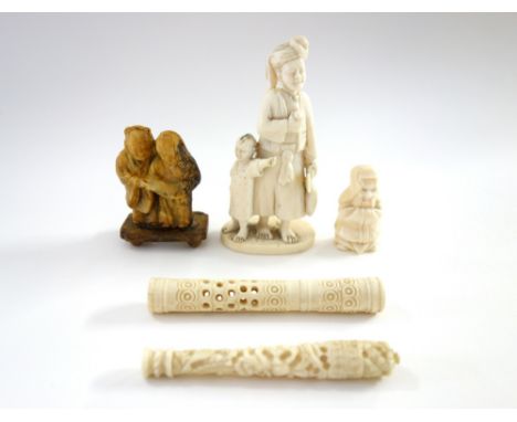 A small Indian ivory carving of a man and child, late 19th/early 20th century, standing on an oval base, 9.5cm.high; also a s