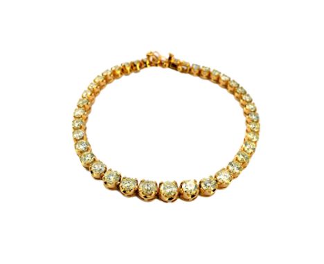 A gold and diamond set line bracelet, claw set with a row of circular cut diamonds, graduating in size to the centre stone, o