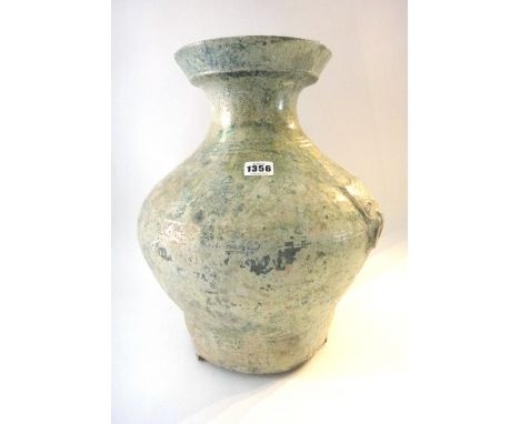 A Chinese green glazed pottery wine jar, Hu, Han Dynasty, of baluster form with mask and ring handles, 42cm. high; also a gre