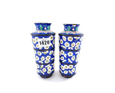 A pair of Canton enamel vases, early 19th century, of tapered cylindrical form, decorated with prunus against a blue `cracked