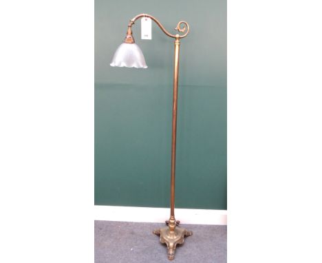 An Edwardian brass standard lamp, with scroll arm and frosted glass shade on a triform base and lion paw feet, 166.5cm high. 