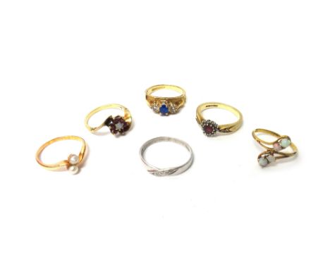 A 9ct gold, opal and ruby set seven stone cluster ring, in a cross over design, a 9ct gold and opal set four stone ring in a 