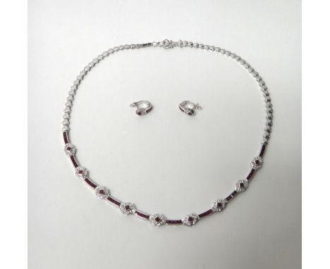A white gold, diamond and ruby set necklace, the front with a row of nine ruby and diamond set clusters, with ten rows of fou