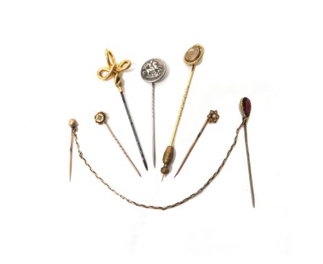 A Victorian gold stick pin, glazed with an oval hair locket compartment at the centre, within a serpentine surround, detailed