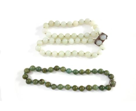 A Chinese pale celadon jade choker necklace, 20th century, with silver clasp; also a matching bracelet, a spinach jade neckla
