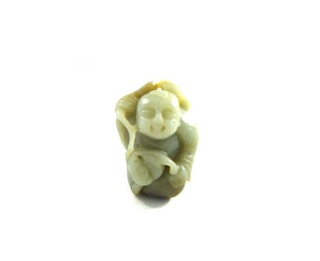  A celadon jade figure of a man, probably 19th century, carved squatting and carrying a string of coins across his shoulders,