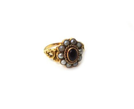 A gold, carbuncle garnet and seed pearl set oval cluster ring, mounted with the oval carbuncle garnet at the centre, in a sur