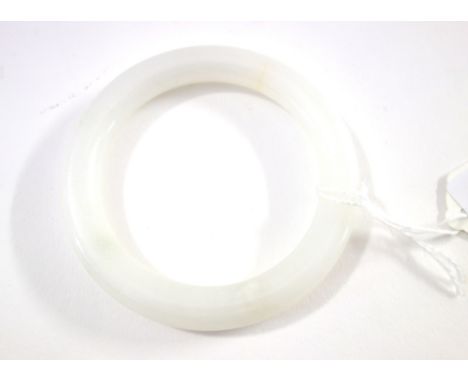 A Chinese jade bangle, the stone of white tone, 8.5cm. to outer rim.