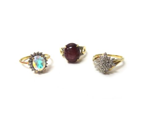 A 9ct gold ring, claw set with an oval cabochon ruby, between diamond set two stone shoulders, a 9ct gold and diamond set clu