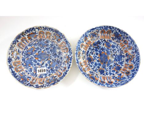 A pair of Chinese porcelain plates, Kangxi, painted in underglaze-blue and enamelled in iron-red and gilding with flowers, (a