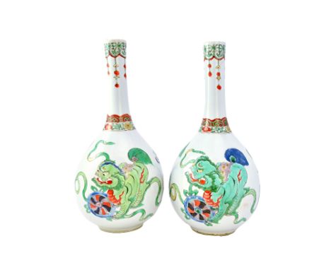 A pair of Chinese famille-verte bottle vases, Kangxi, each painted with buddhist lions and ribbons, (a.f), 27cm.high. Illustr