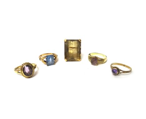 A gold ring, claw set with a large rectangular step cut smoky quartz, a 9ct gold ring, mounted with an oval cut amethyst, a g