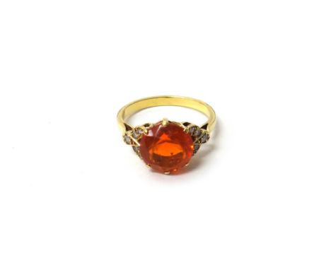 A gold, fire opal and diamond set ring, claw set with the circular cut fire opal at the centre, between diamond set five ston