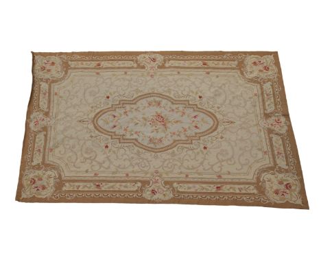 in light browns, pale pink and red, with a floral medallion and borders, 104 x 68in. (264 x 172cm.) Excellent condition.