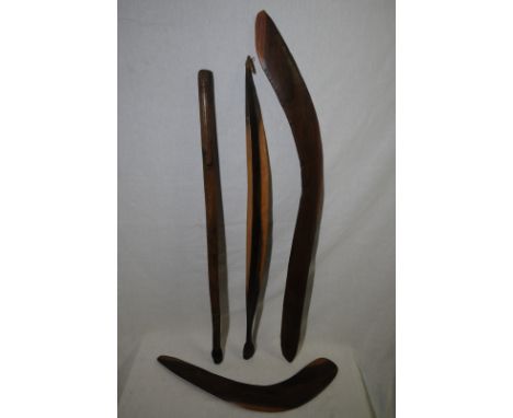 Four Aboriginal type carved wood items including two boomerang style items and a sword item item with curved edges and tapere