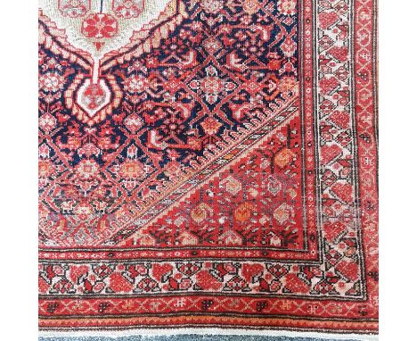 MALAYER RUG with central medallion and geometric designs on a red and blue ground 195cm x 116cmThere is some thinning and app