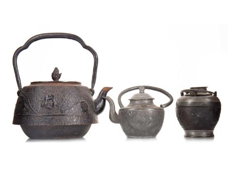 JAPANESE CAST IRON TEA KETTLE MEIJI PERIOD (1868-1912) decorated in relief with mask, fish and other item, along a small tea 