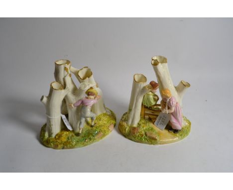 A pair of Royal Worcester figure groups of children playing amongst trees, each with impressed mould No. W10, 16cm high