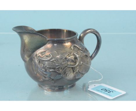 A Chinese silver cream jug with dragon design to main body, character mark to base, weight approx 200g
