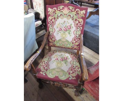 A 17th century style open arm chair with tapestry back and seat and leafed carved arms and carved front stretcher&nbsp;