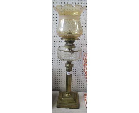 An oil lamp, with brass column and glass shade