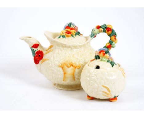 A Clarice Cliff 'Celtic Harvest' teapot and sugar bowl, embossed fruit and wheat sheaf decoration, marked to base, and Newpor