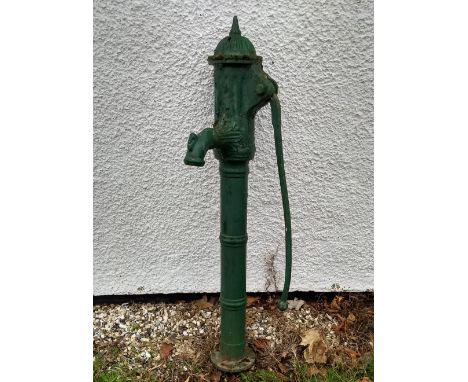 A green painted cast iron water pump, domed top with finial